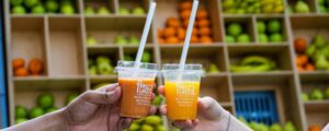 Two fruitful juices in front of Fruitful cart